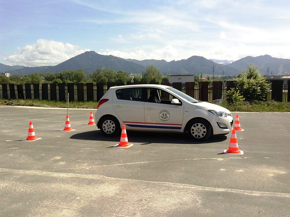 Výcvikové auto na cvičisku, v pozadí hory